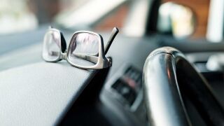 Brille liegt auf Amaturenbrett im Auto