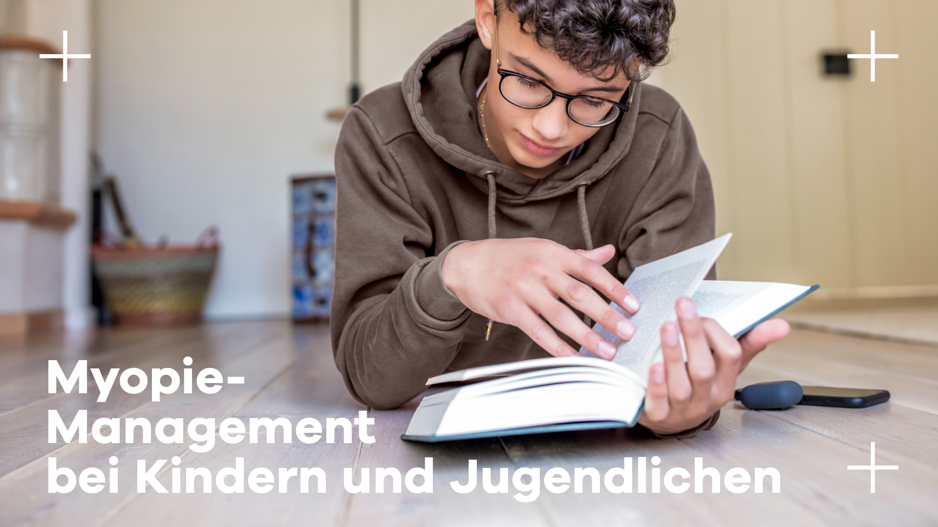 auf dem Boden lesendes Kind Brillenträger Myopie Hoya