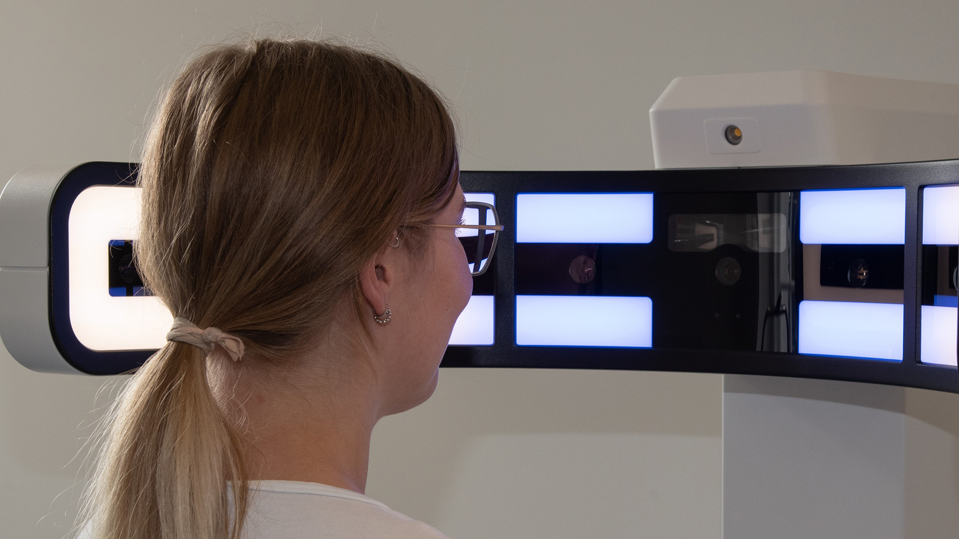 Frau vor optometrischem Instrument