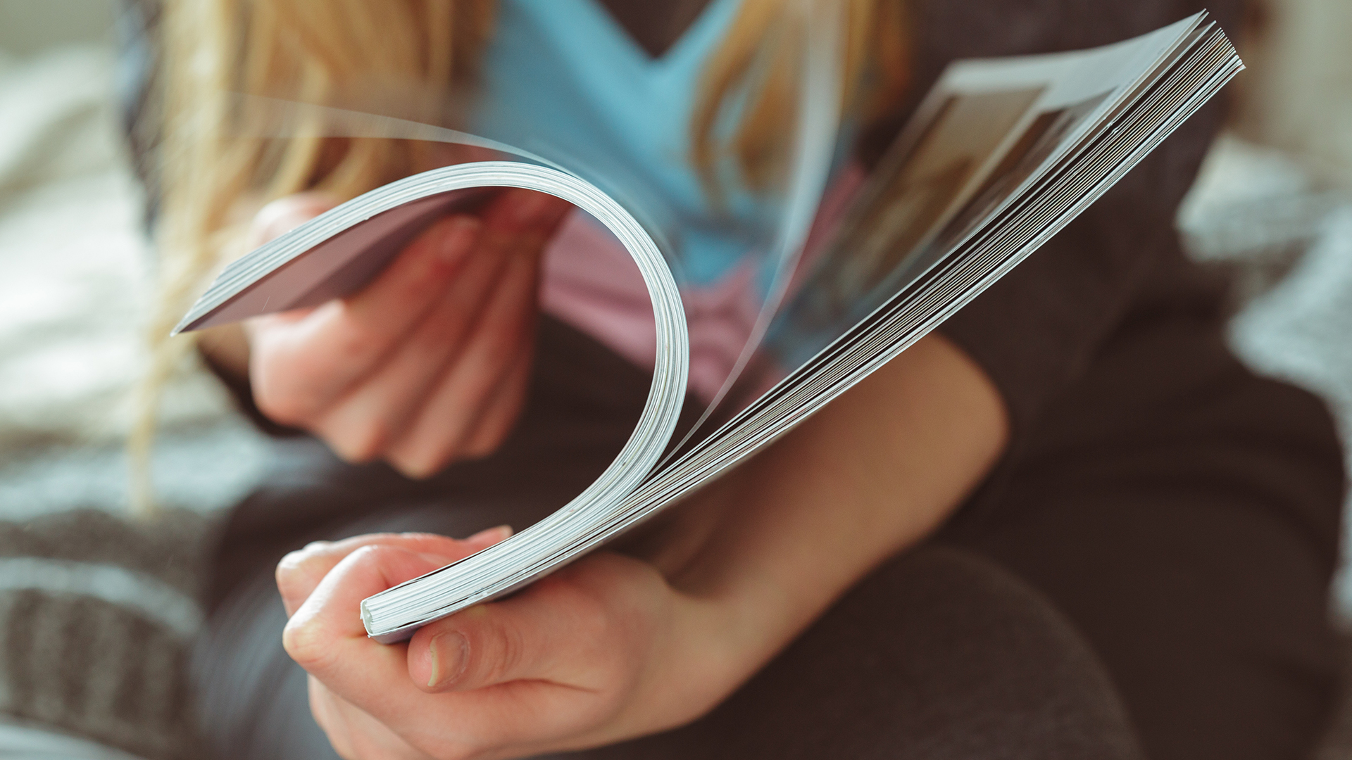 Frau blättert in einem Magazin